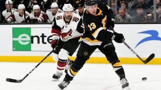 Feb 8, 2020; Boston, Massachusetts, USA; Boston Bruins center Charlie Coyle (13) shoots the puck in front of Arizona Coyotes center Brad Richardson (15) during the third period at the TD Garden. Mandatory Credit: Brian Fluharty-USA TODAY Sports
