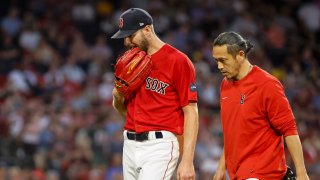 Chris Sale #41 of the Boston Red Sox bites on his glove as he leaves the game in the middle of the fourth inning against the Cincinnati Reds at Fenway Park