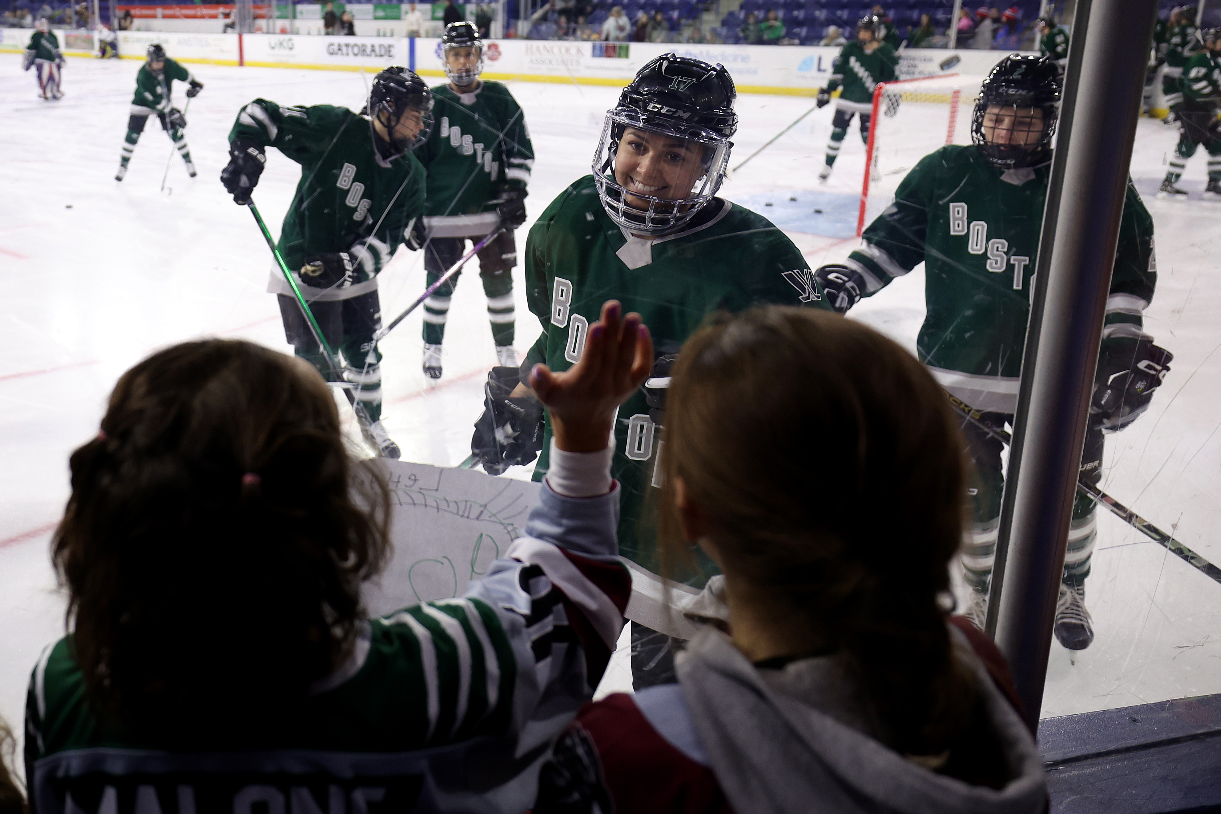 LOWELL, MASSACHUSETTS – JANUARY 03: Young fans interact with Taylor Girard #17 of Boston before the PWHL game against the Minnesota at Tsongas Center on January 03, 2024 in Lowell, Massachusetts.