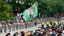 A Boston Celtics banner flies above the crowd in Copley Square along the route of the parade.