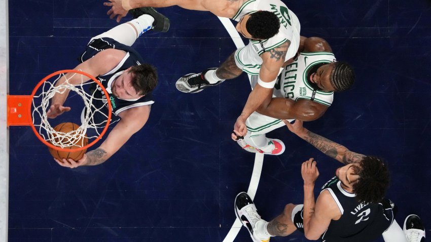 Jun 12, 2024; Dallas, Texas, USA; Dallas Mavericks guard Luka Doncic (77) shoots the ball against Boston Celtics forward Jayson Tatum (0) and guard Jaylen Brown (right) during the third quarter during game three of the 2024 NBA Finals at American Airlines Center. Mandatory Credit: Peter Casey-USA TODAY Sports