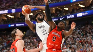 United States center Joel Embiid (11) drives to the basket against Canada center Kelly Olynyk (13) and point guard Luguentz Dort (0) during the first half of an exhibition basketball game Wednesday, July 10, 2024, in Las Vegas.