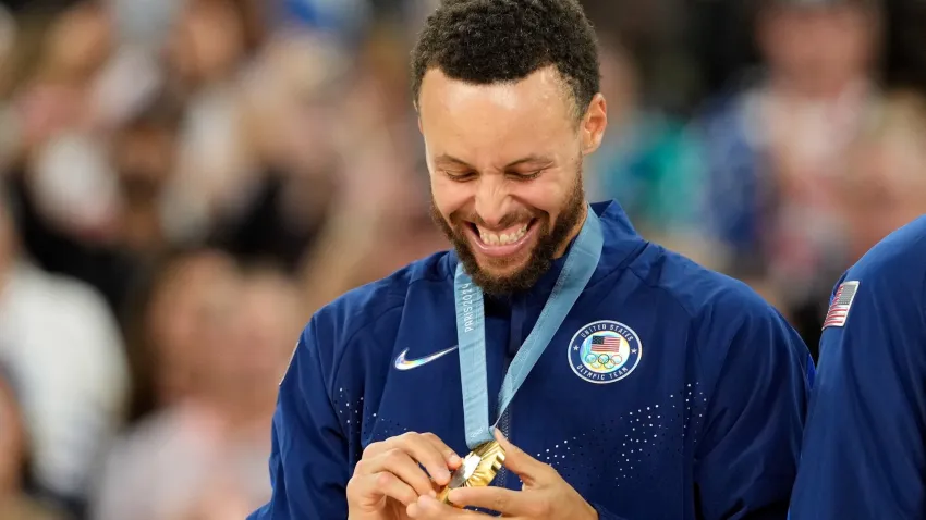 Steph Curry looks at his gold medal