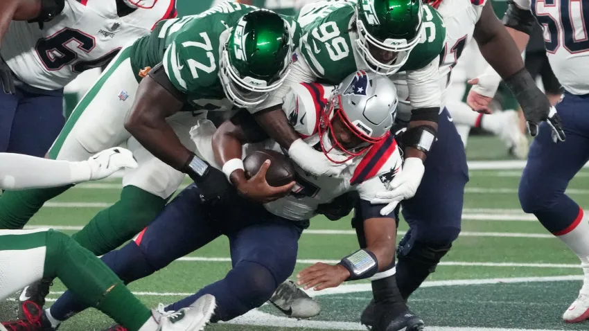 Sep 19, 2024; East Rutherford, New Jersey, USA;  New England Patriots quarterback Jacoby Brissett (7) sacked by New York Jets defensive end Micheal Clemons (72)  and  defensive end Will McDonald IV (99)  in the 1st half at MetLife Stadium. Mandatory Credit: Robert Deutsch-Imagn Images