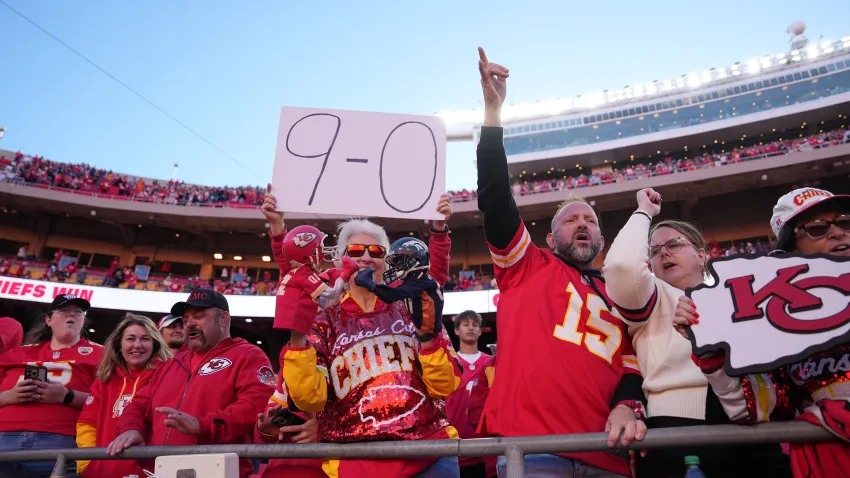 Chiefs fan holding a "9-0" sign