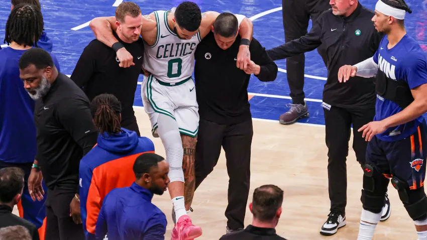 May 12, 2025; New York, New York, USA; Boston Celtics forward Jayson Tatum (0) is helped off the court by after an injury in the second half during game four of the second round for the 2025 NBA Playoffs against the New York Knicks at Madison Square Garden. Tatum would leave the game with an injury after this play. Mandatory Credit: Vincent Carchietta-Imagn Images
