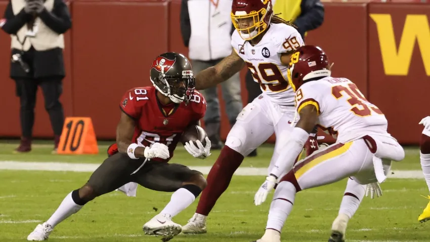 Jan 9, 2021; Landover, Maryland, USA; Tampa Bay Buccaneers wide receiver Antonio Brown (81) runs with the ball as Washington Football Team defensive end Chase Young (99) and Washington Football Team free safety Jeremy Reaves (39) chase in the second quarter at FedExField. Mandatory Credit: Geoff Burke-USA TODAY Sports
