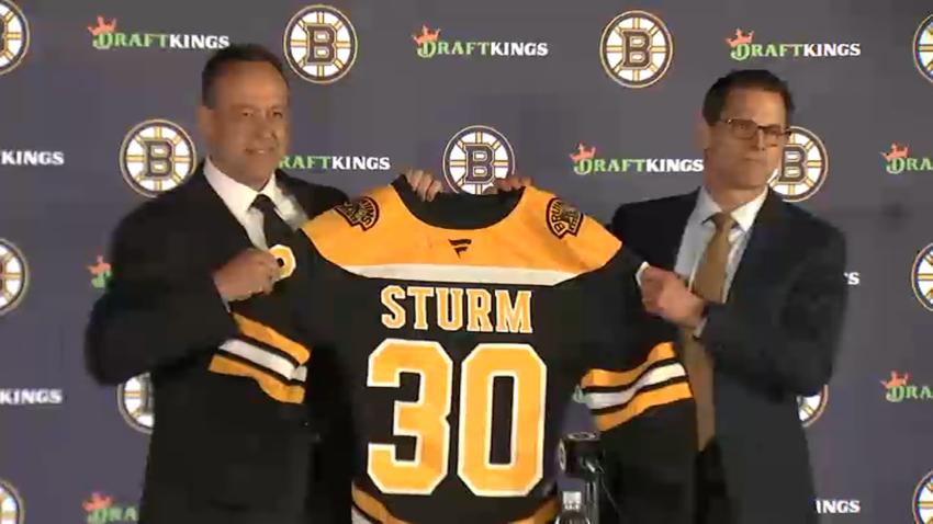 New Boston Bruins head coach Marco Sturm (left) and GM Don Sweeney hold a No. 30 jersey with Sturm's name on it at Sturm's introductory news conference on Tuesday, June 10, 2025.