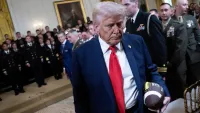 Donald Trump holds a football as he departs a ceremony to present the Commander-in-Chief's Trophy to the US Naval Academy football team, the Navy Midshipmen, in the East Room of the White House on April 15, 2025 in Washington, DC.
