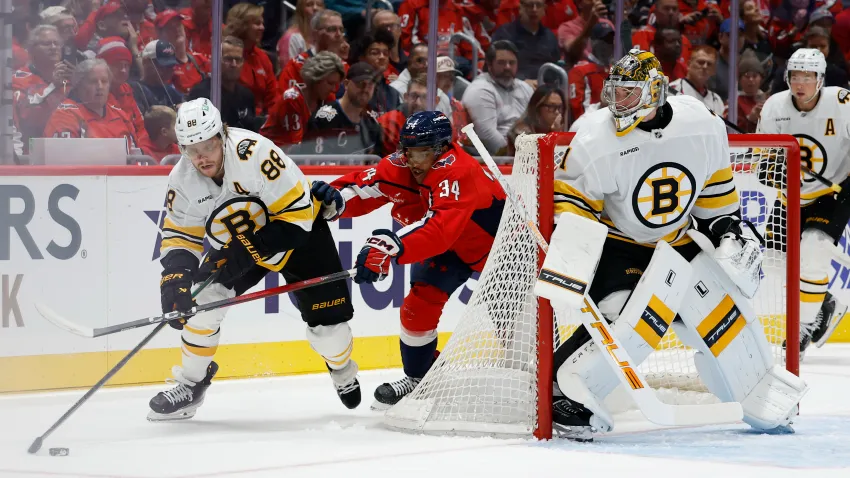 Oct 8, 2025; Washington, District of Columbia, USA; Boston Bruins right wing David Pastrnak (88) skates with the puck against behind Bruins goaltender Jeremy Swayman (1) as Washington Capitals right wing Justin Sourdif (34) chases during the first period at Capital One Arena. Mandatory Credit: Geoff Burke-Imagn Images